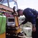 Milwaukee Road M&W employee (name?) tuning up Speeder coil, Three Forks, Montana